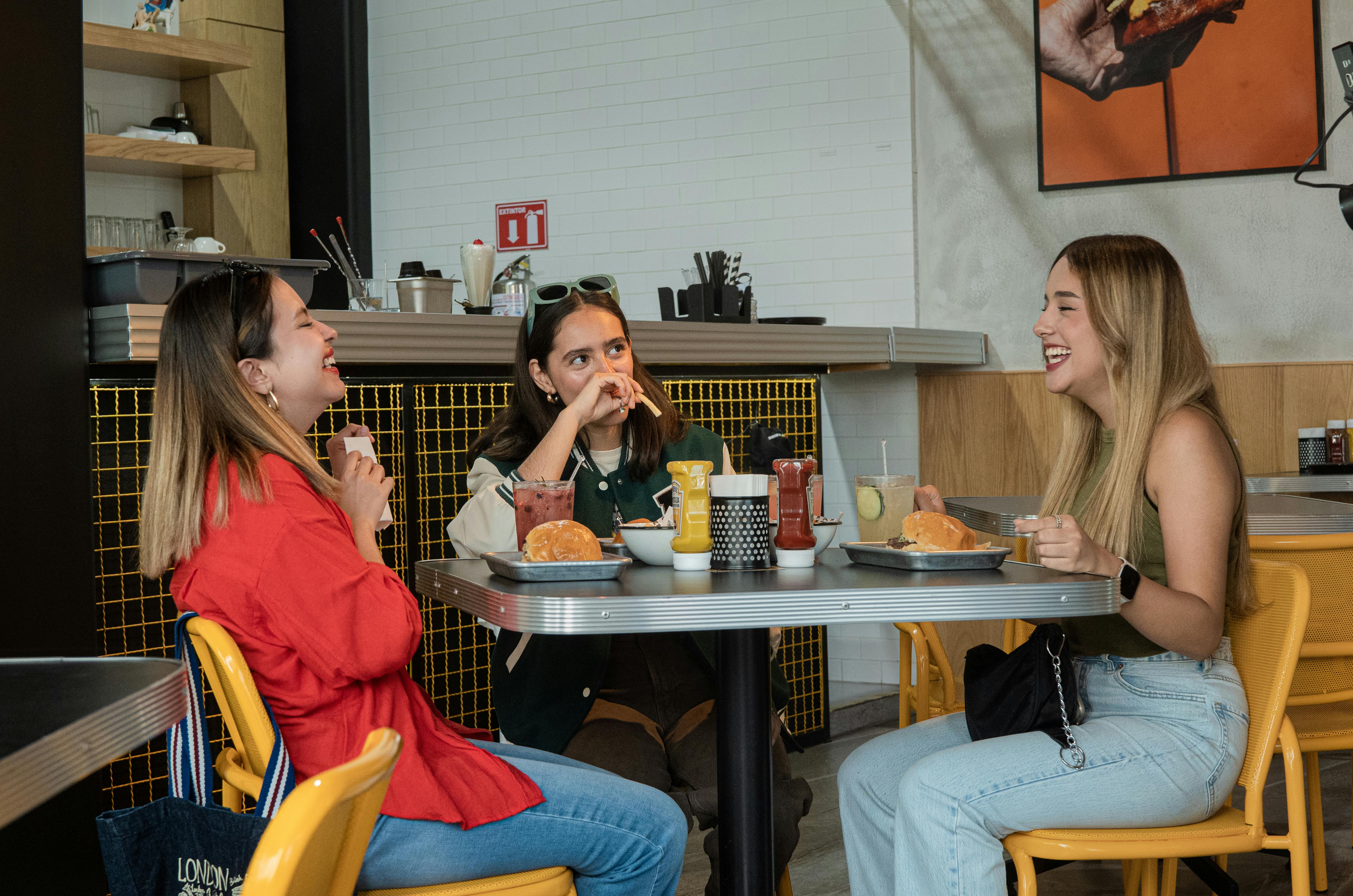 Friends laughing while eating burgers