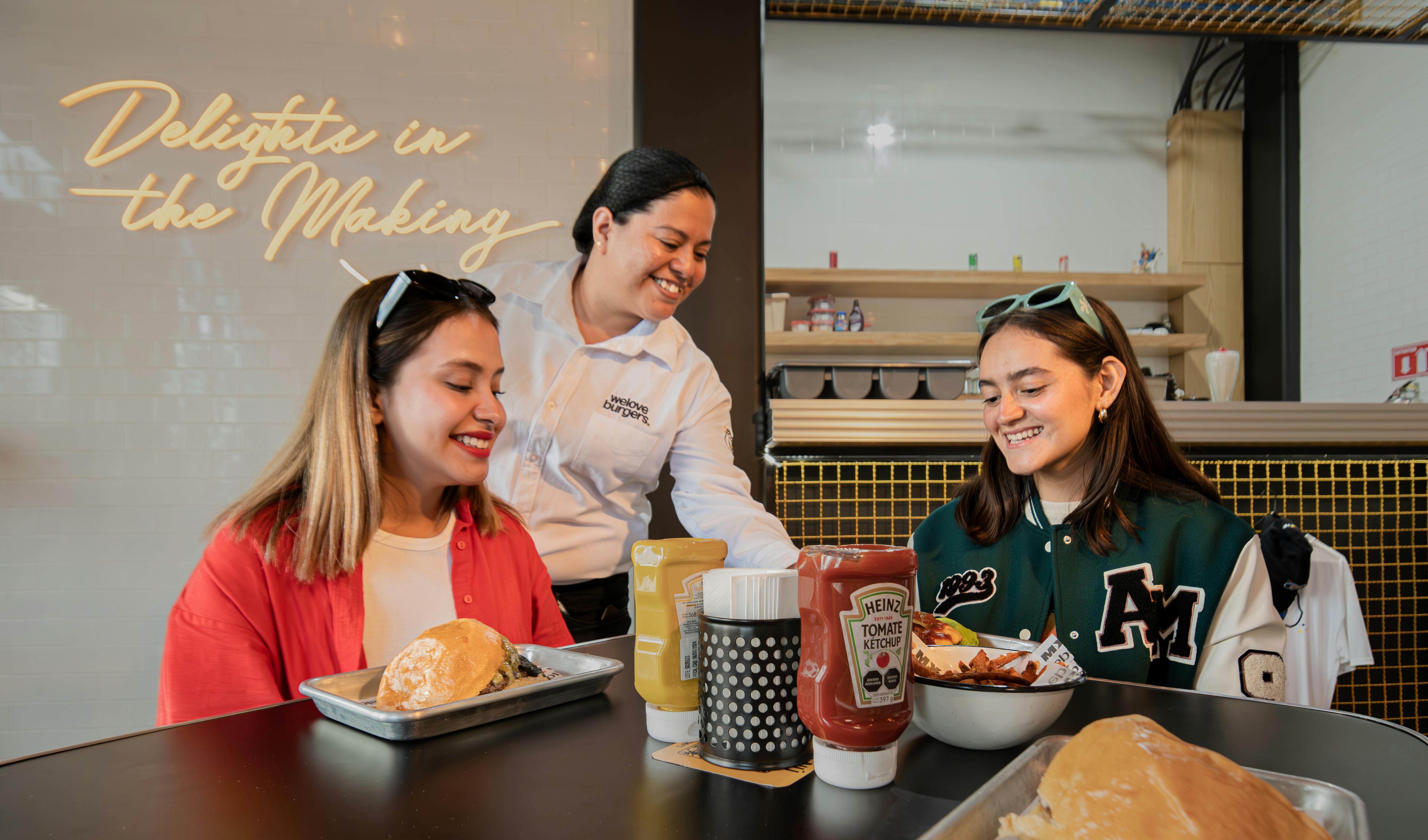 Server bringing burgers to guests in a restaurant